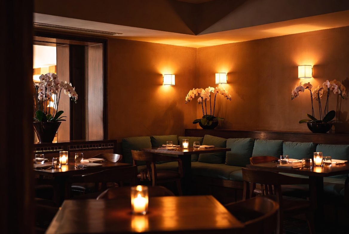 Warmes Restaurant-Ambiente mit Orchideen und Kerzenlicht